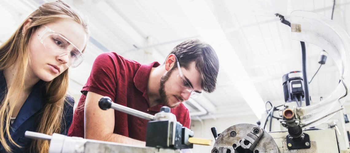 Engineers working on a heavy machinery for their project work