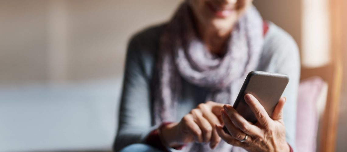 Shot of a senior woman using a mobile phone in a retirement home